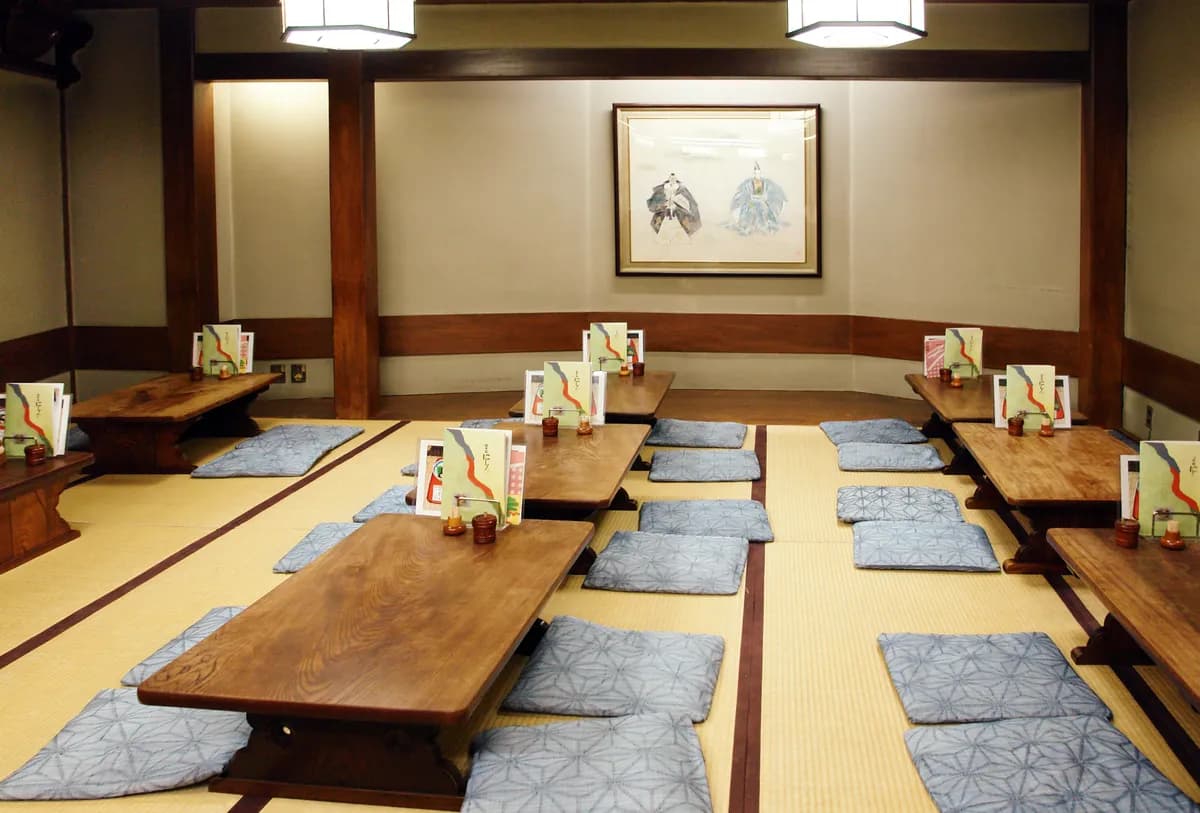 BookNoFees Primer slike: Japonska jedilnica z nizkimi lesenimi mizami in sedežnimi blazinami na tatami preprogah