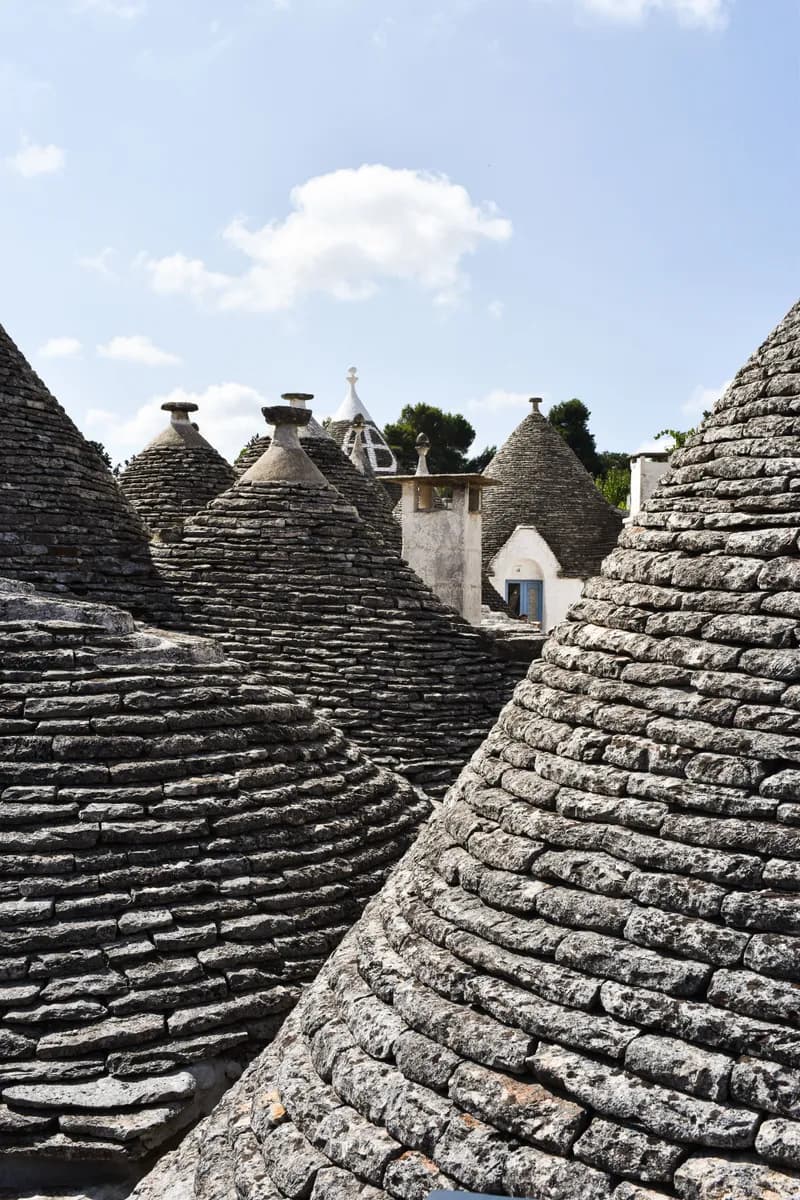 Primer slike BookNoFees: Kamnite stožčaste strehe trulli, ki stojijo tesno druga ob drugi