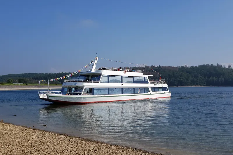 Potniška ladja MS Sorpesee na jezeru v bližini Sunderna, z gozdom na nasprotnem bregu