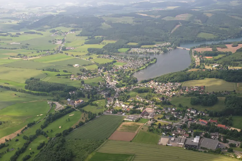 Jezero Sorpesee iz zraka, z vasico Amecke na vzhodnem obrežju in gozdnatimi hribi Sauerlanda v ozadju