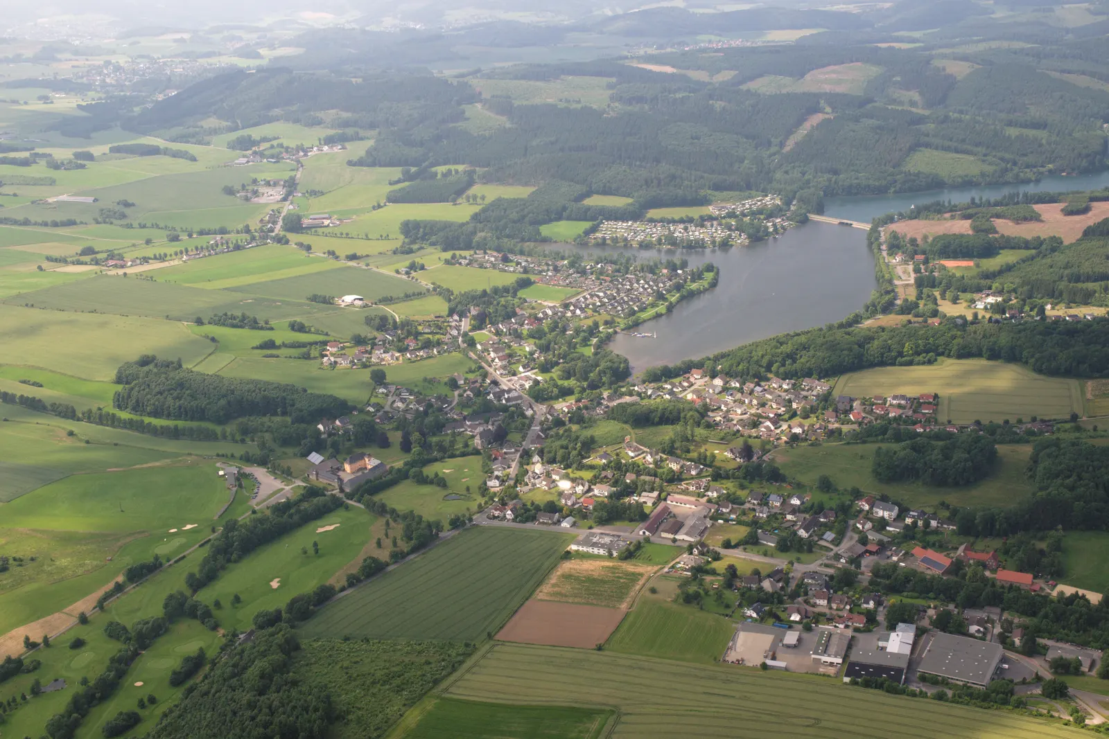 Jezero Sorpesee iz zraka, z vasico Amecke na vzhodnem obrežju in gozdnatimi hribi Sauerlanda v ozadju