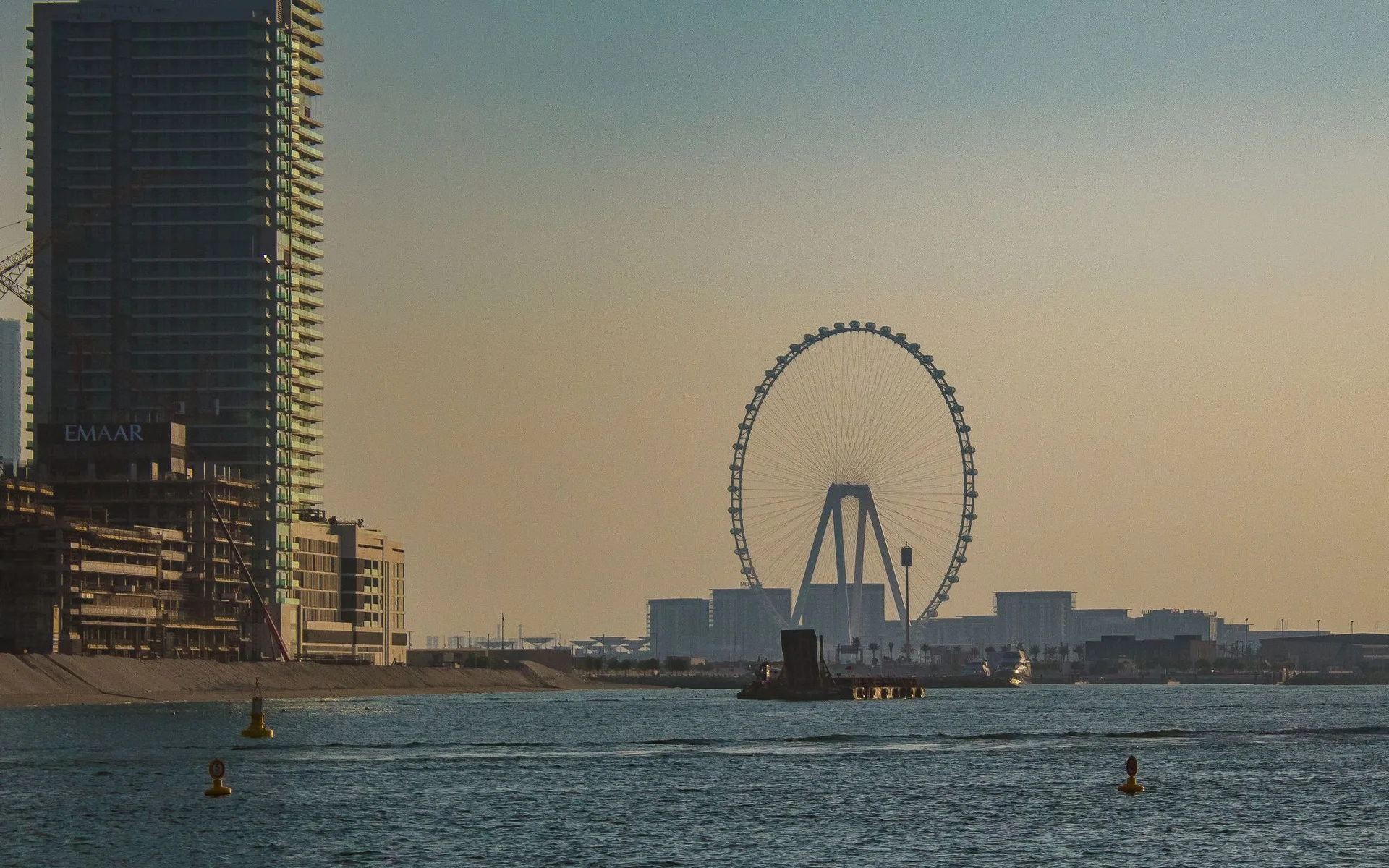 Panorama Dubaja z velikim vrtiljakom ob sončnem zahodu